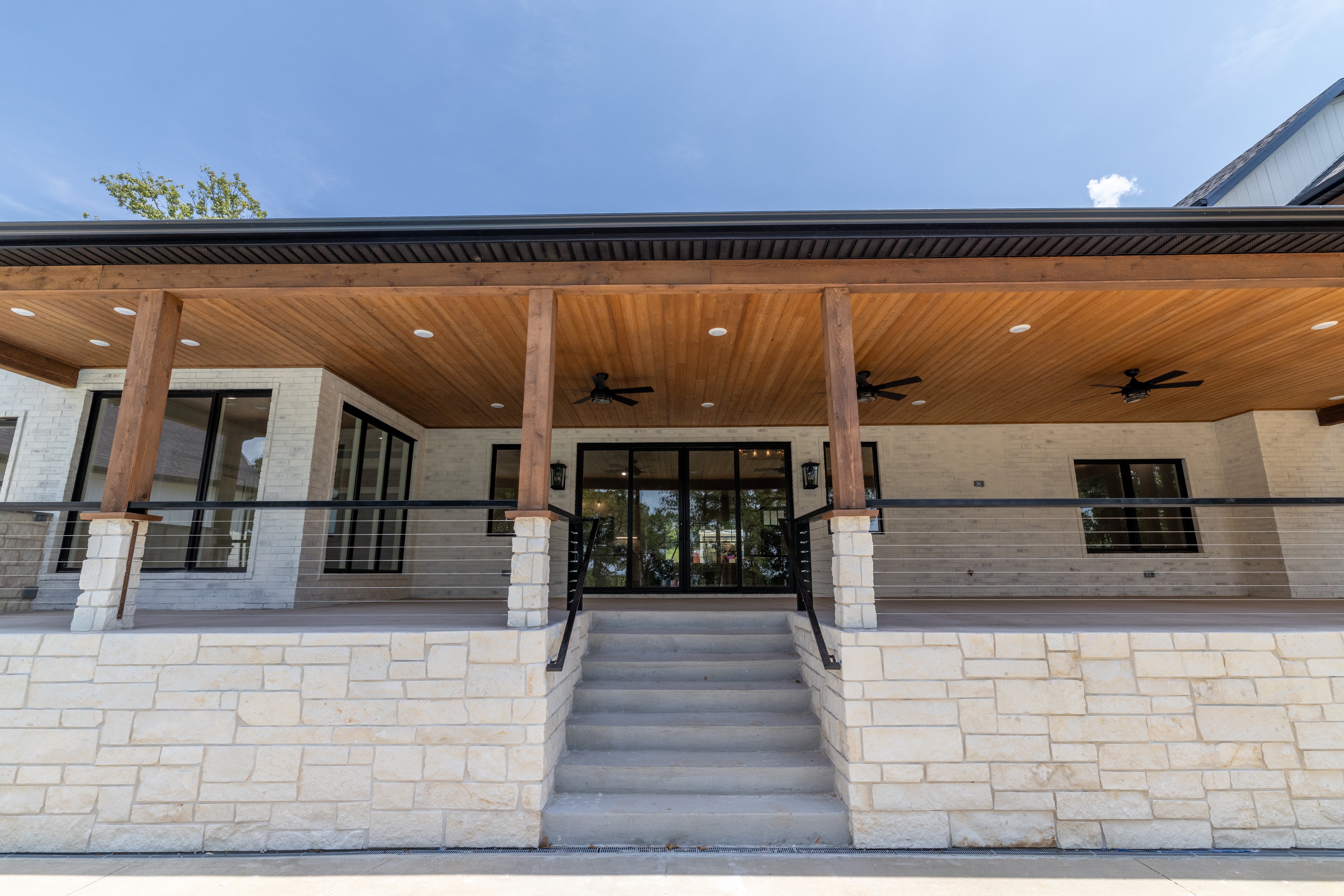 Custom home exterior entry with stone and wood porch