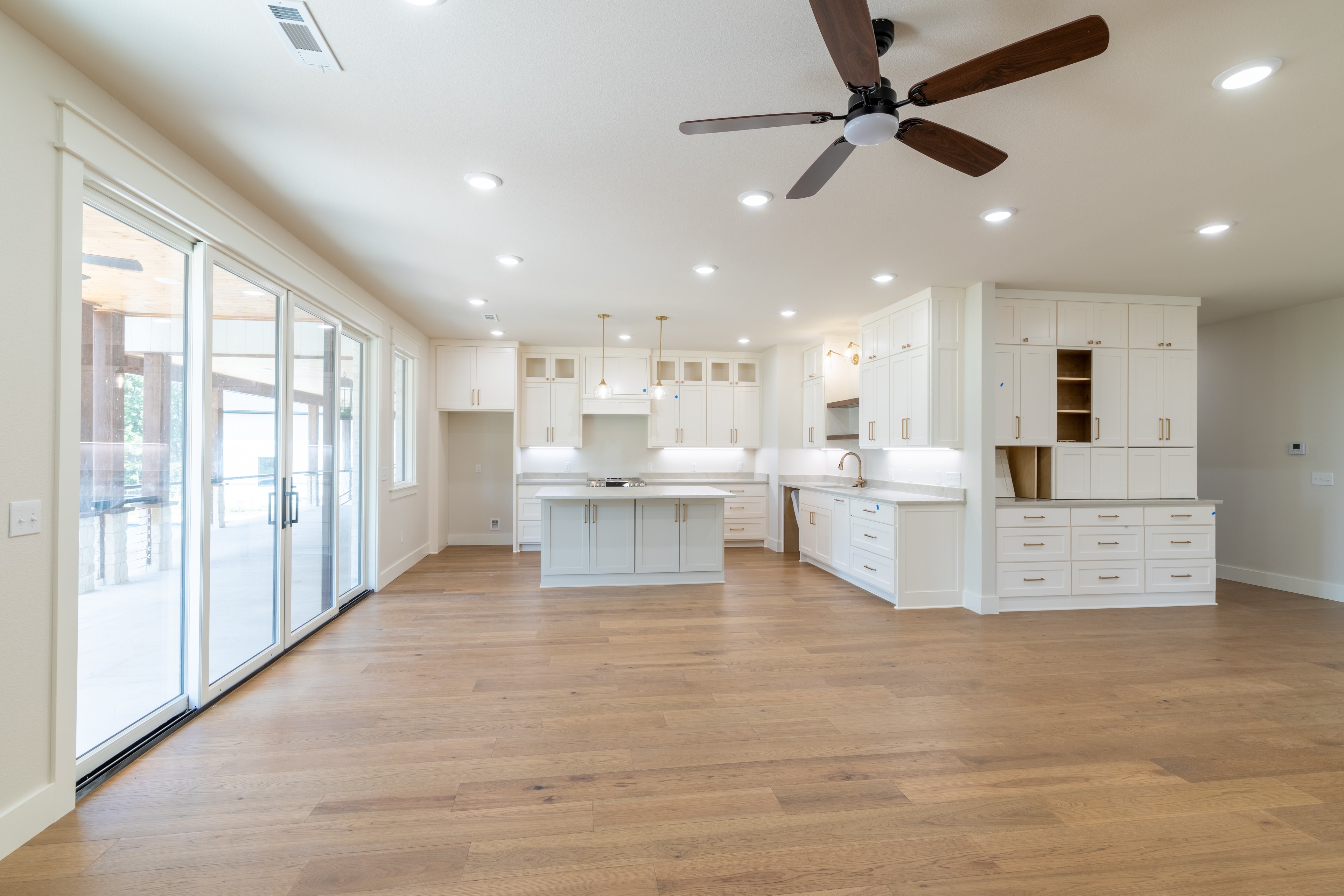 White kitchen with large island and hardwood floors